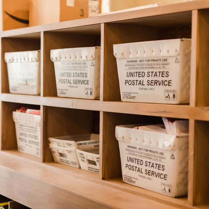 USPS mailboxes on wooden shelves.
